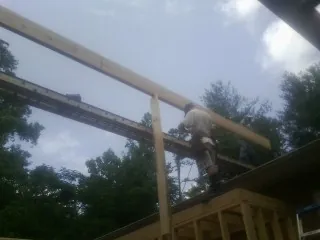 Carpenter setting a ridge beam over a new addition frame — Ice Dam Removal by Roofing Brothers in Hanford