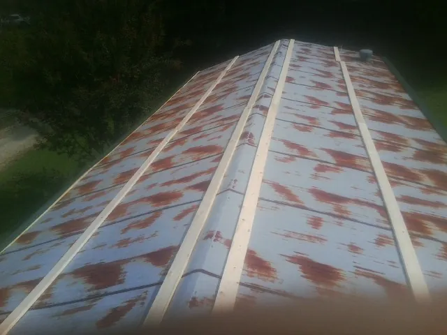 Rusted metal roof panels with new wood purlins before replacement — Storm Damage Roof Repair in Hanford by Roofing Brothers