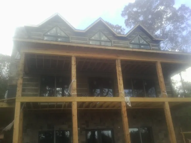 Dormers and porch framing on a large log home under construction — Roof Coating work by our crew in Hanford