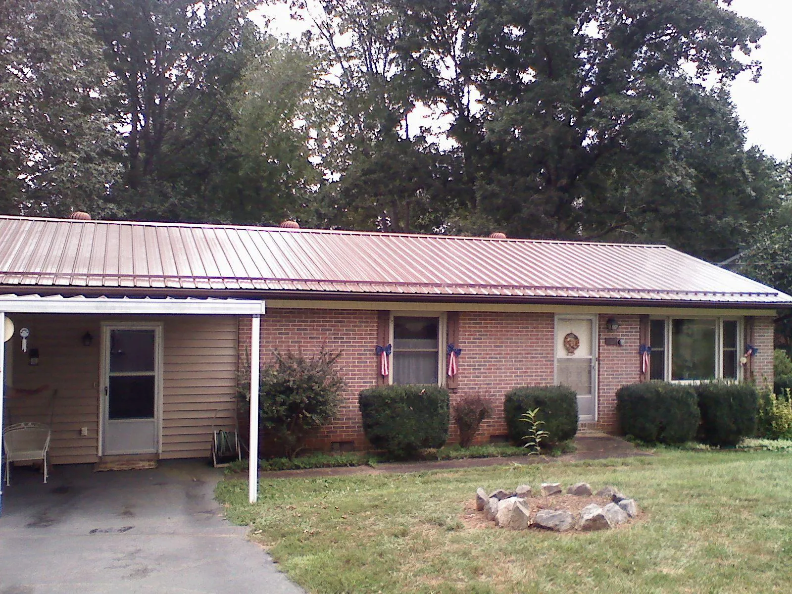 Bronze metal roof and carport on a brick ranch home — Roof Repair work by our crew in Hanford