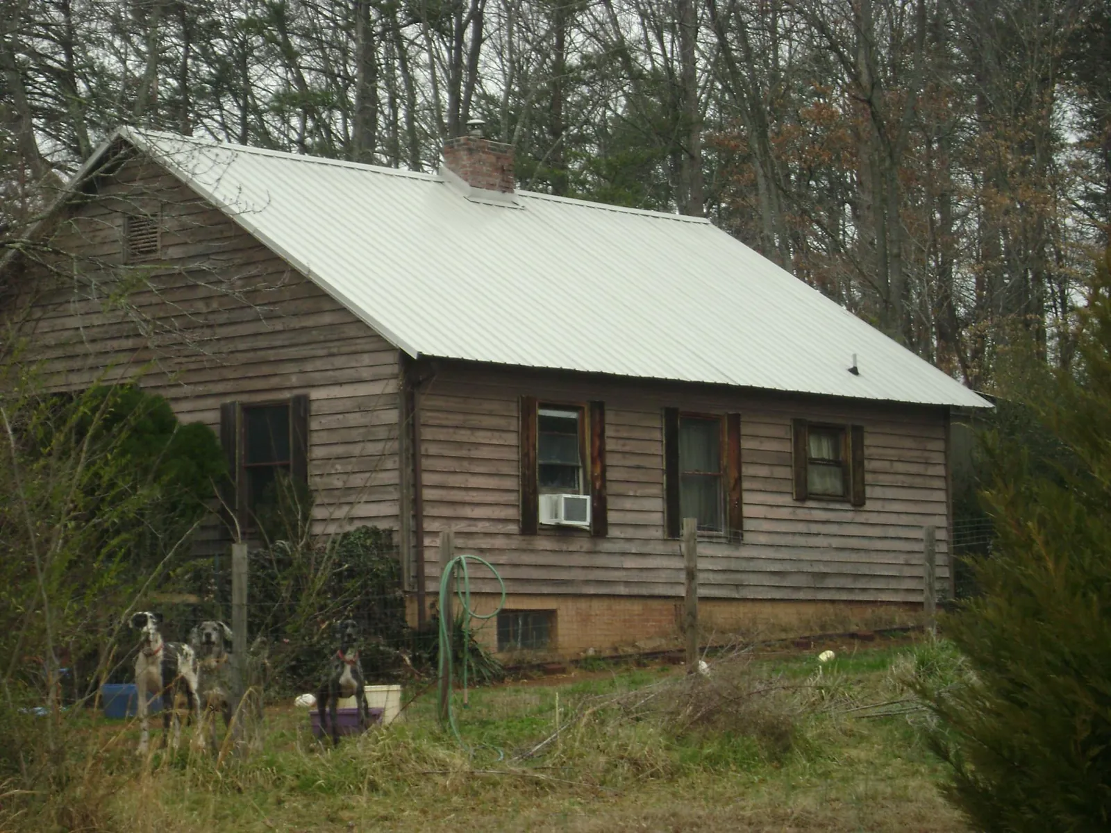 White metal roof on an old wood sided farmhouse, from a Metal Roof Installation job in Hanford